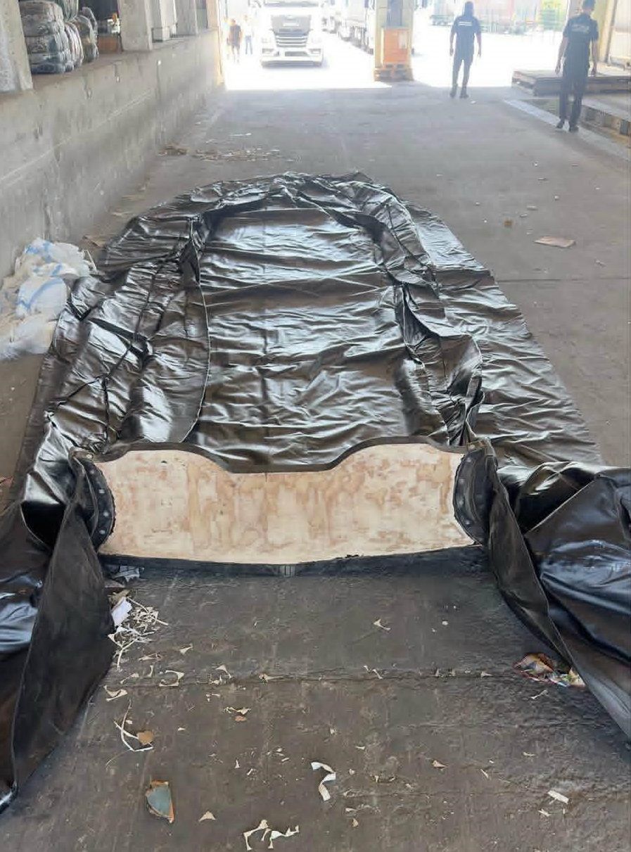 Deflated boat laid out on grey floor