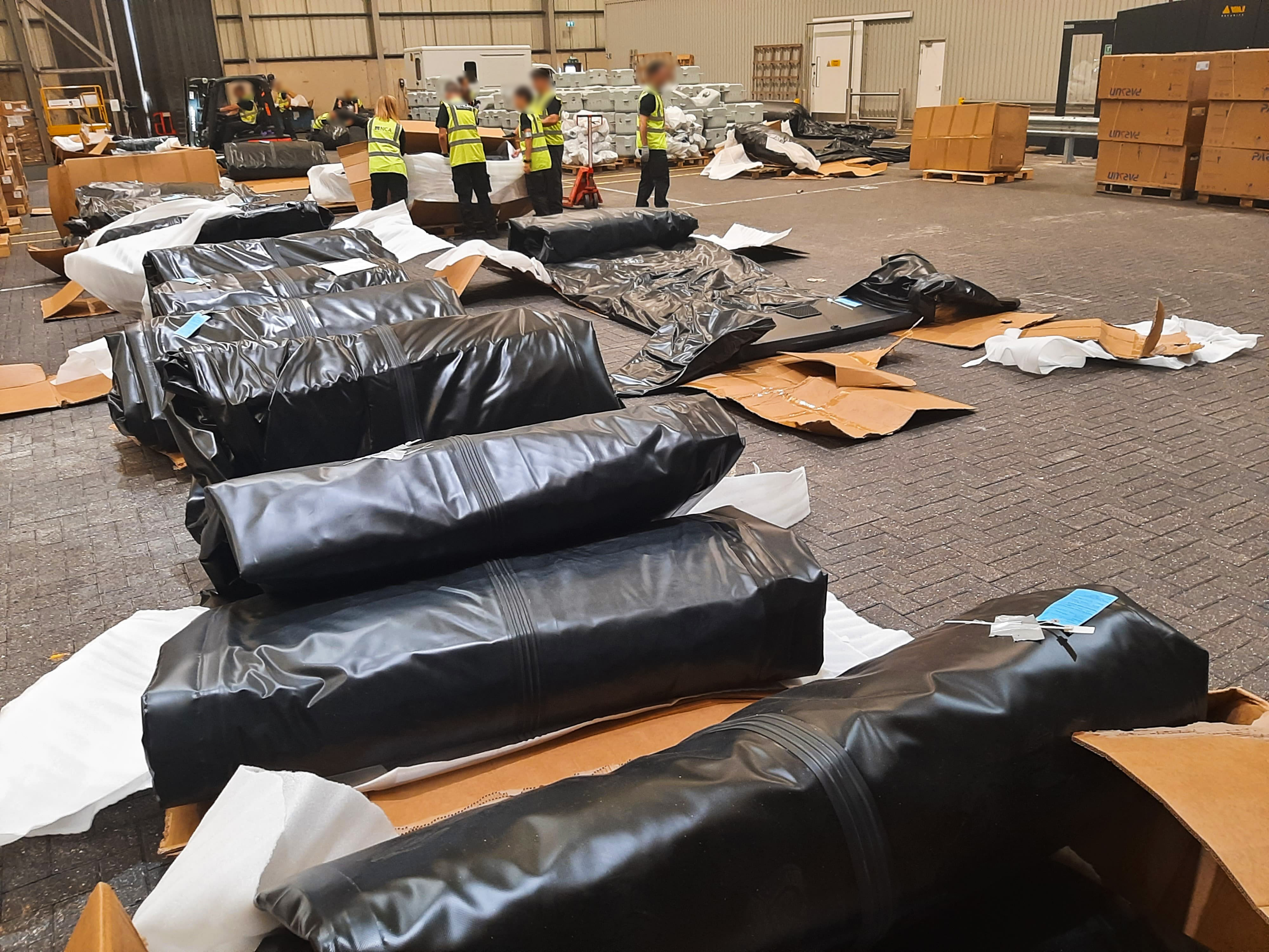 Black rubber boats rolled up on floor of warehouse