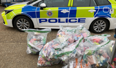 Bags of seized goods in front of a police car