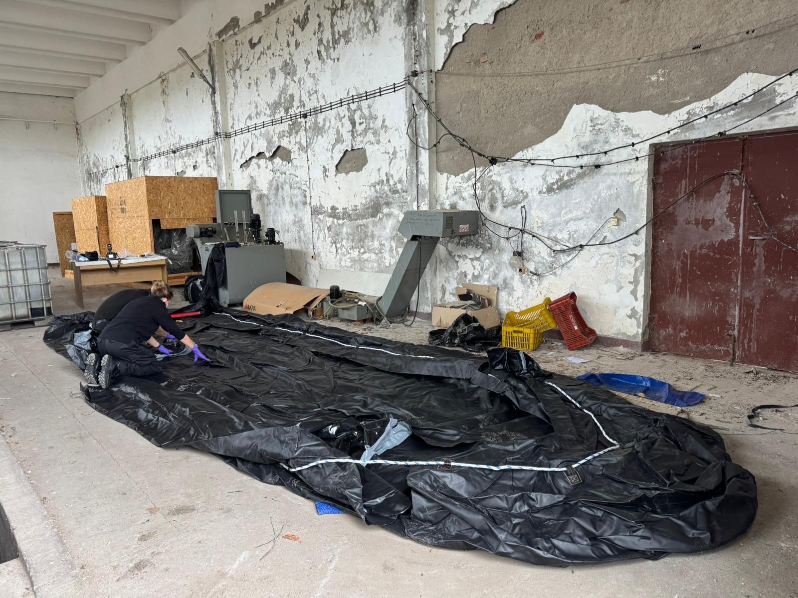 NCA officers forensically examining small boat