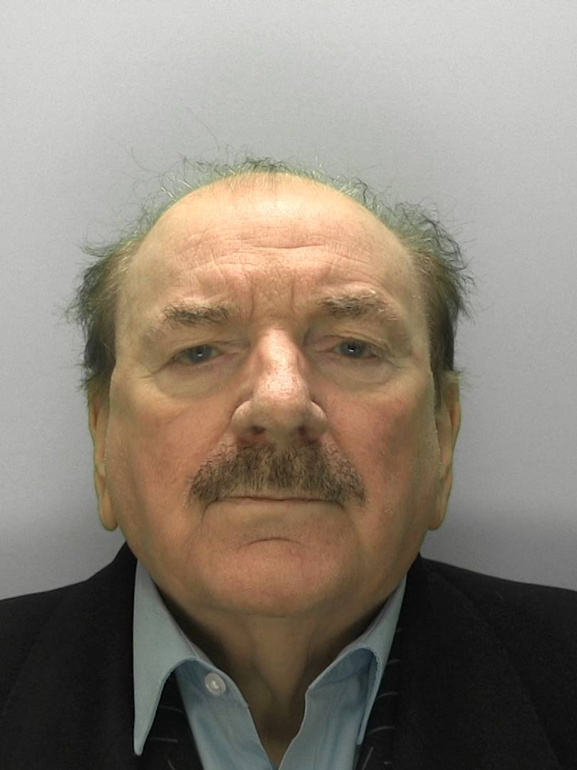 Hugh Rodley custody image of him wearing a dark blazer and blue shirt