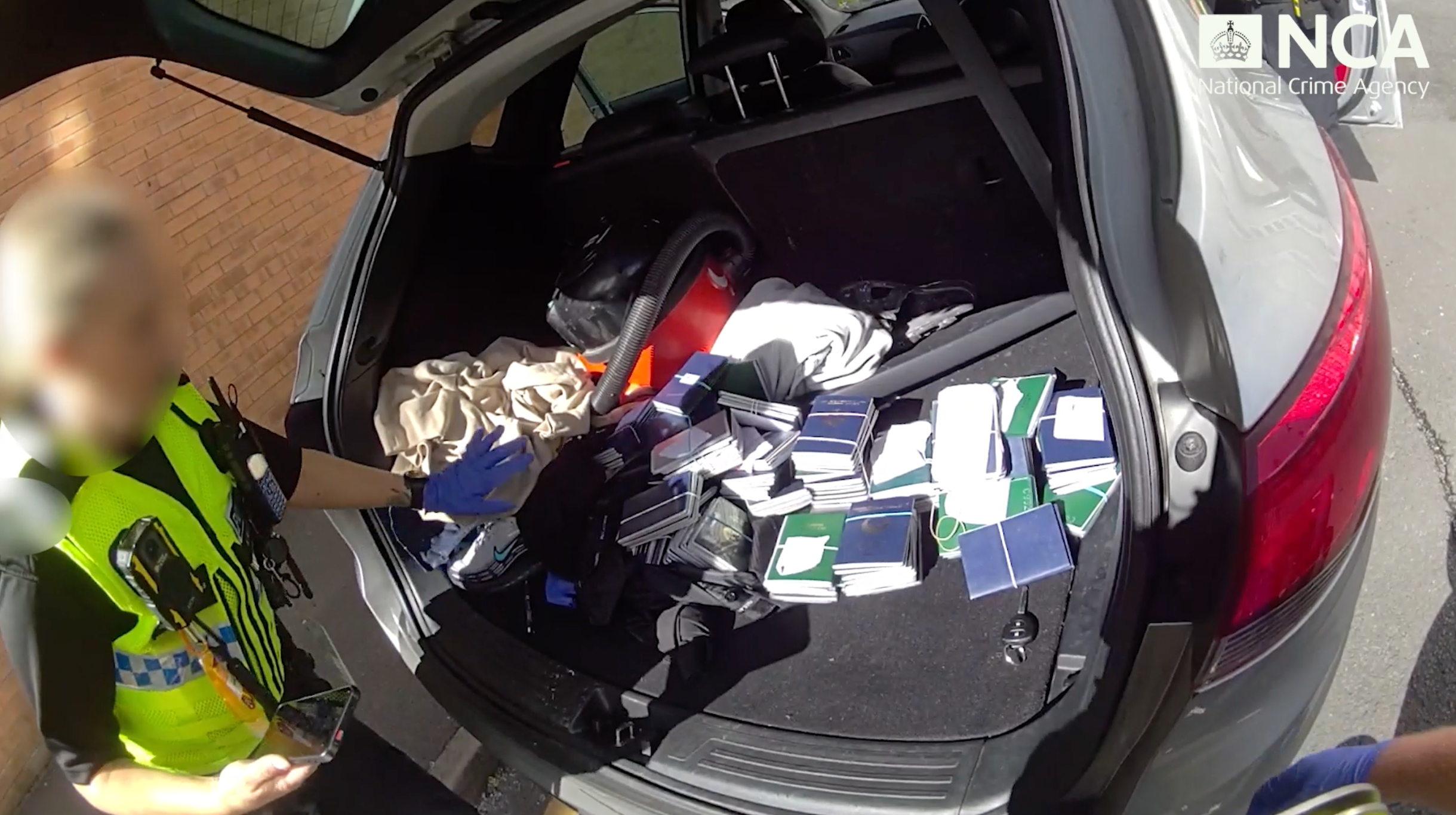 Police officer discovering 220 Vietnamese passports in boot of car
